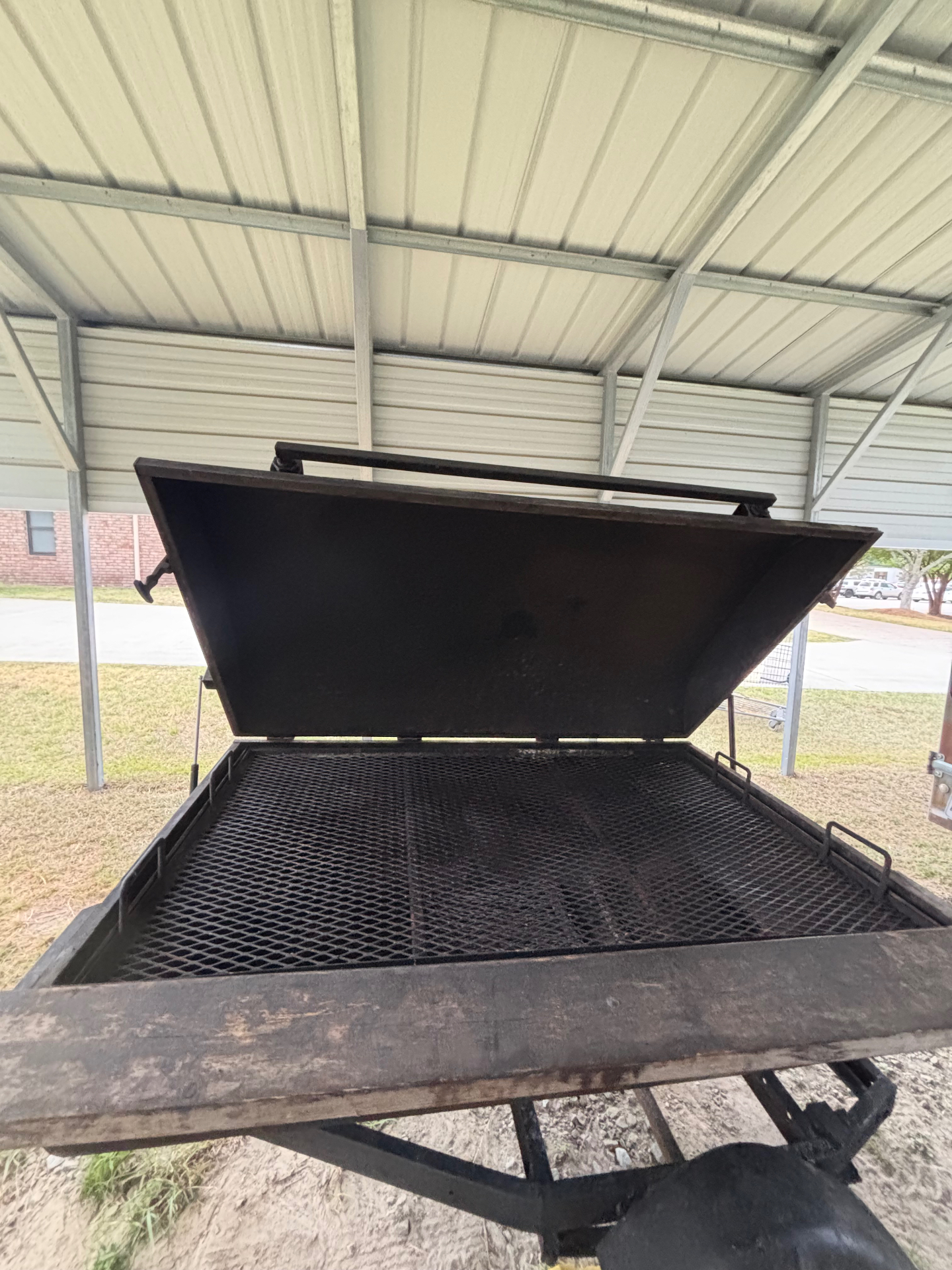 Large pig cooker with open lid ready for a cookout